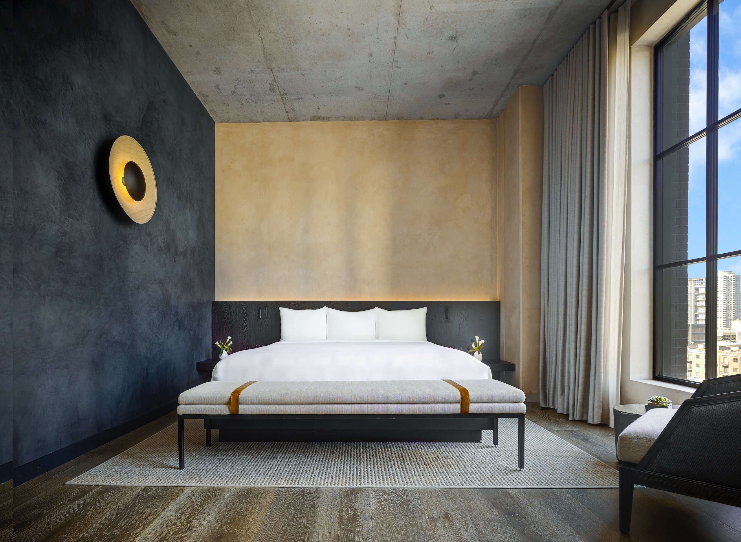 bedroom with slim bench at the foot of a large bed