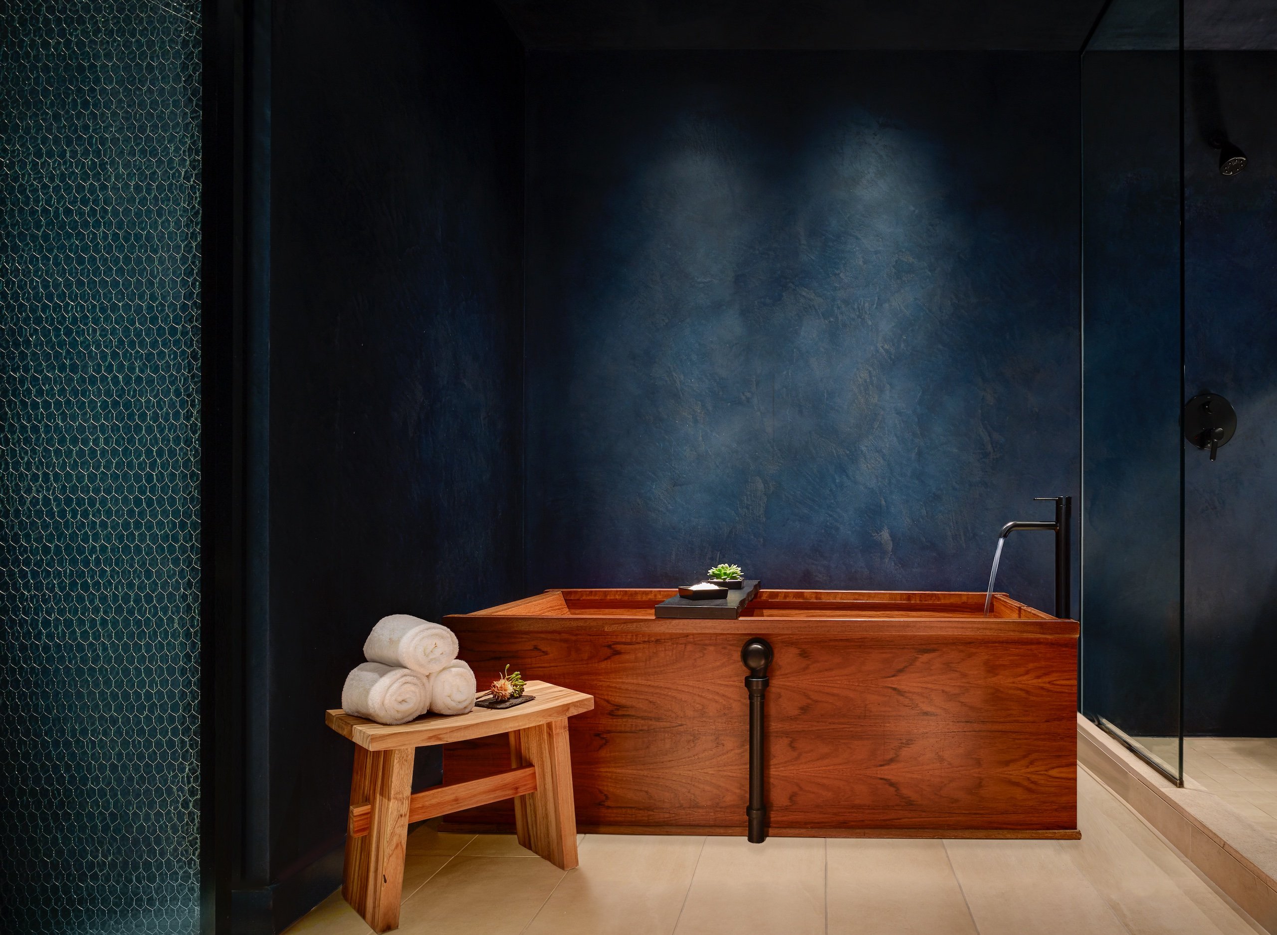 black bathroom with wooden tub