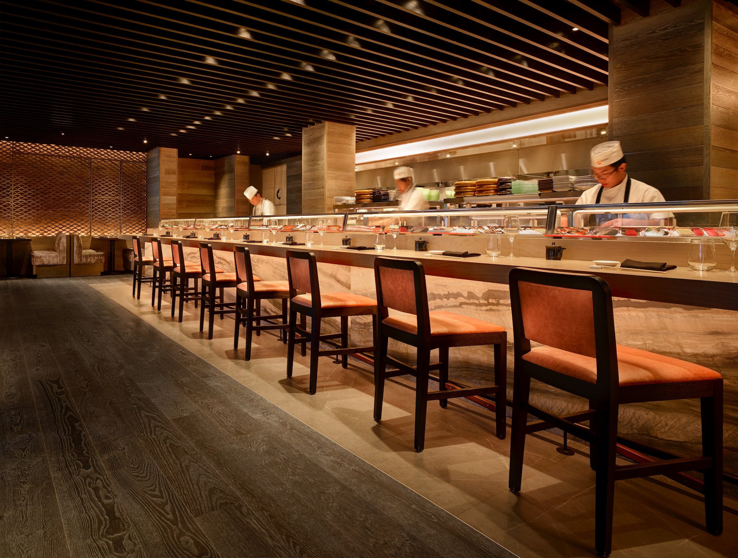 sushi chefs preparing sushi at an empty sushi bar