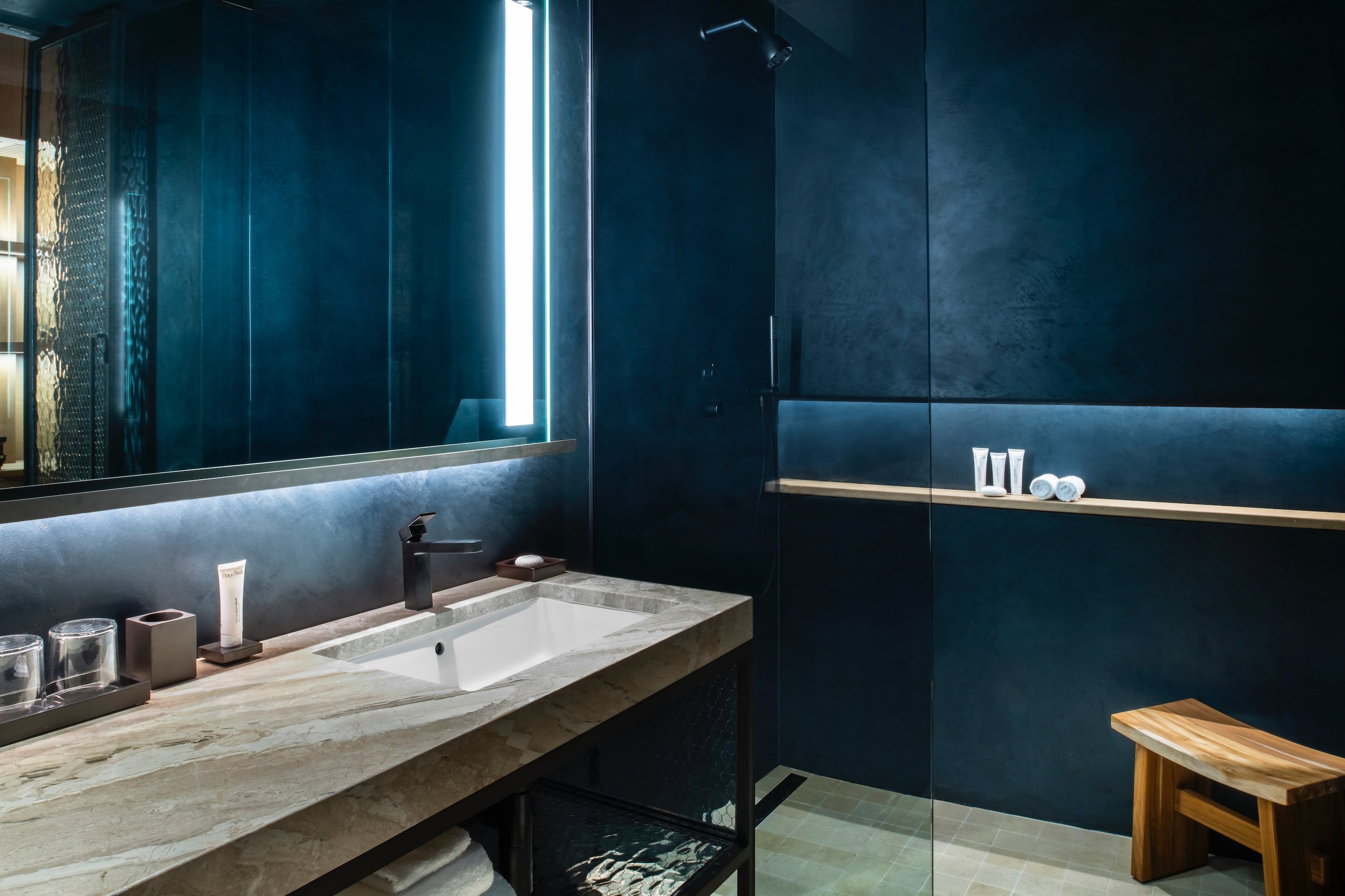 dark bathroom with walk-in shower and large vanity