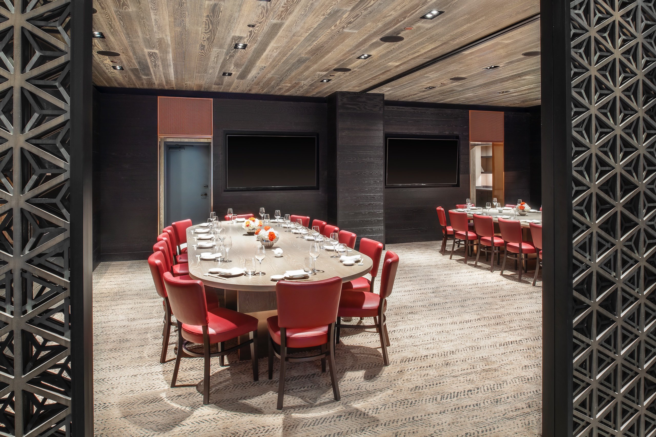 sectioned off dining area with large oval table and red chairs