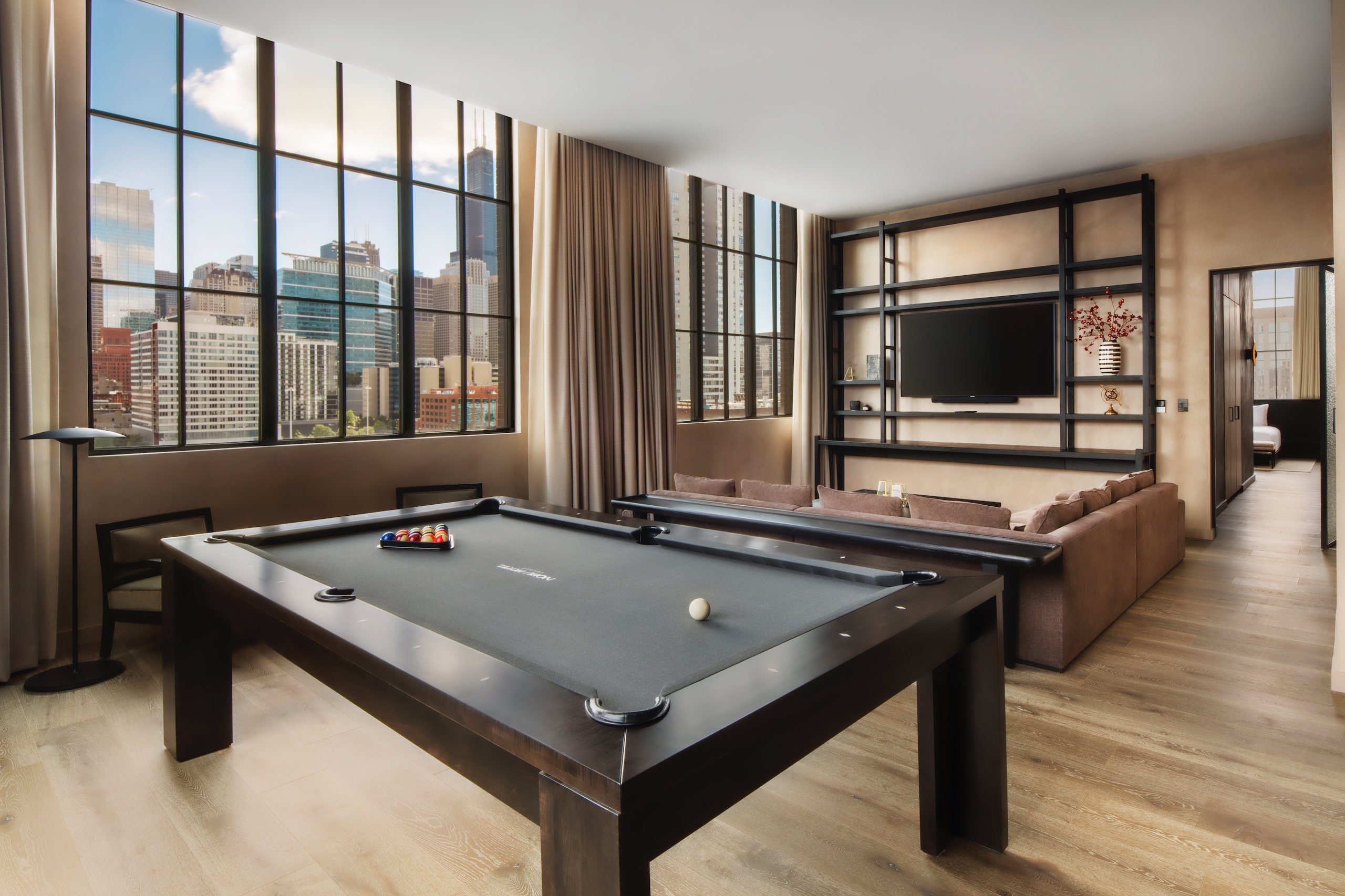 living room with large brown sectional and a dark wood pool table