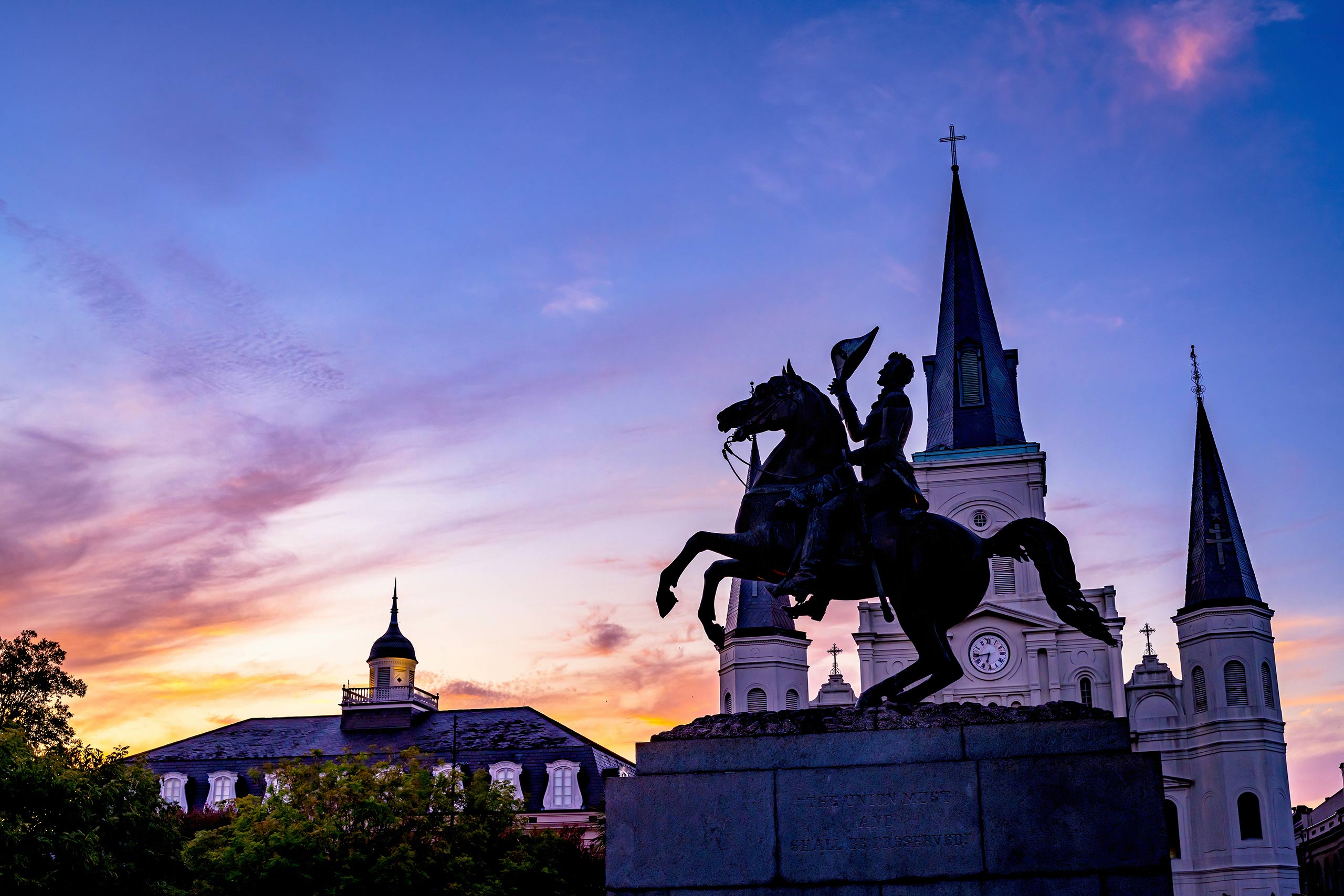 A majestic statue of a man on horseback is positioned in front of a church, blending history and architecture beautifully