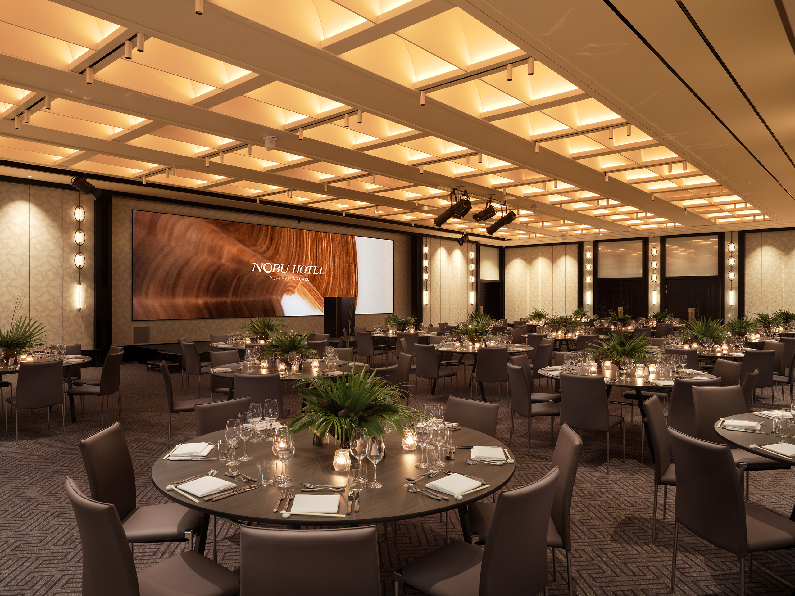 Grey tables and chairs with settings in large Nobu meeting space at Portman Square