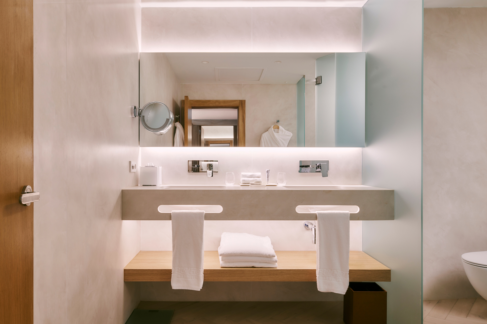 A clean bathroom scene showcasing a sink, toilet, and a stylish mirror above the sink for a modern touch