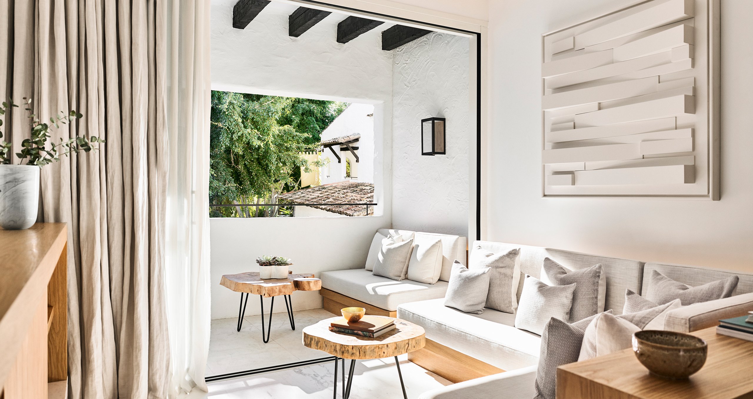 Stylish living room showcasing white furniture and a window, enhancing the room's light and open feel