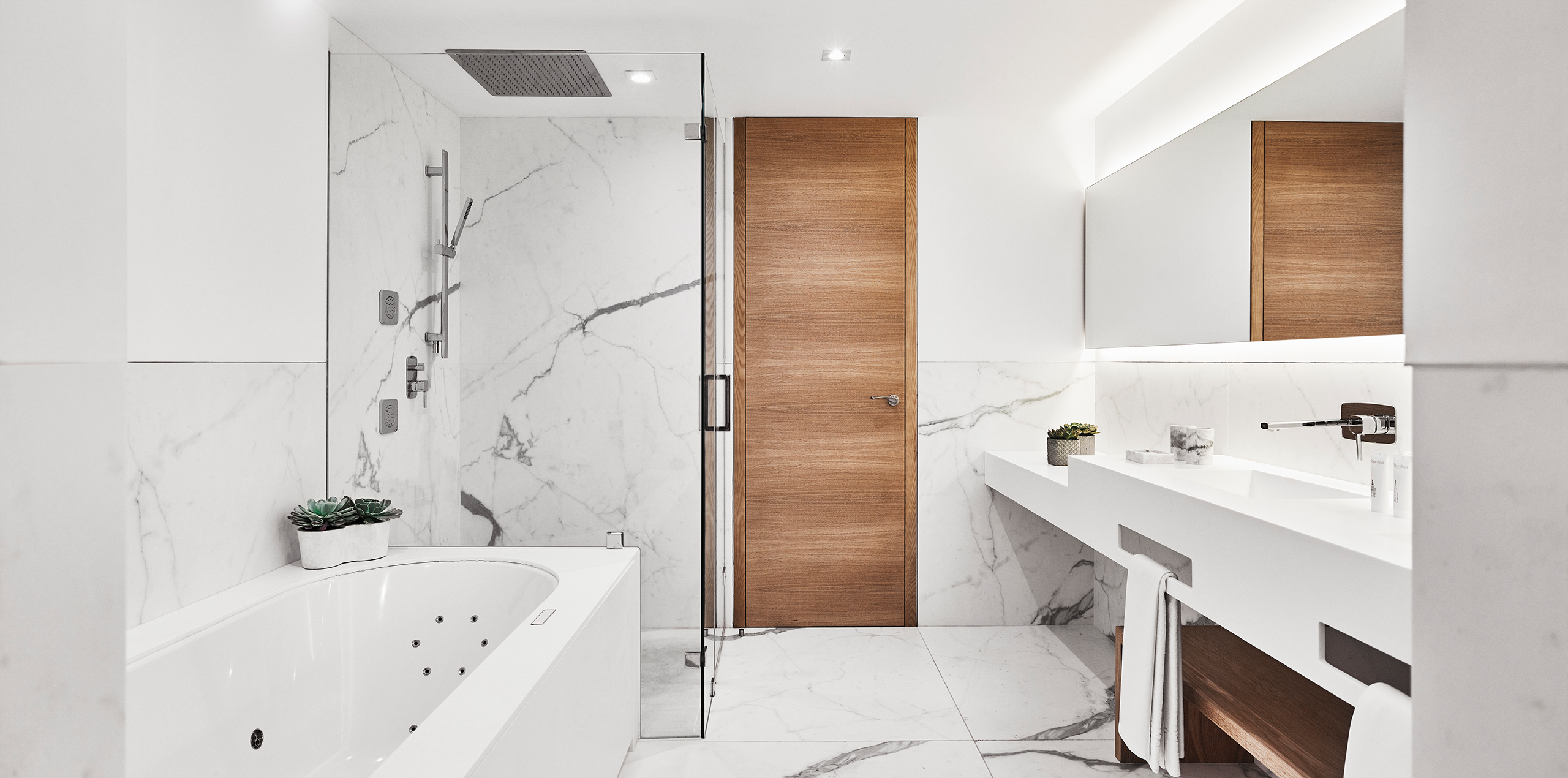 A contemporary bathroom showcasing luxurious marble floors and clean white walls, offering a stylish and serene space