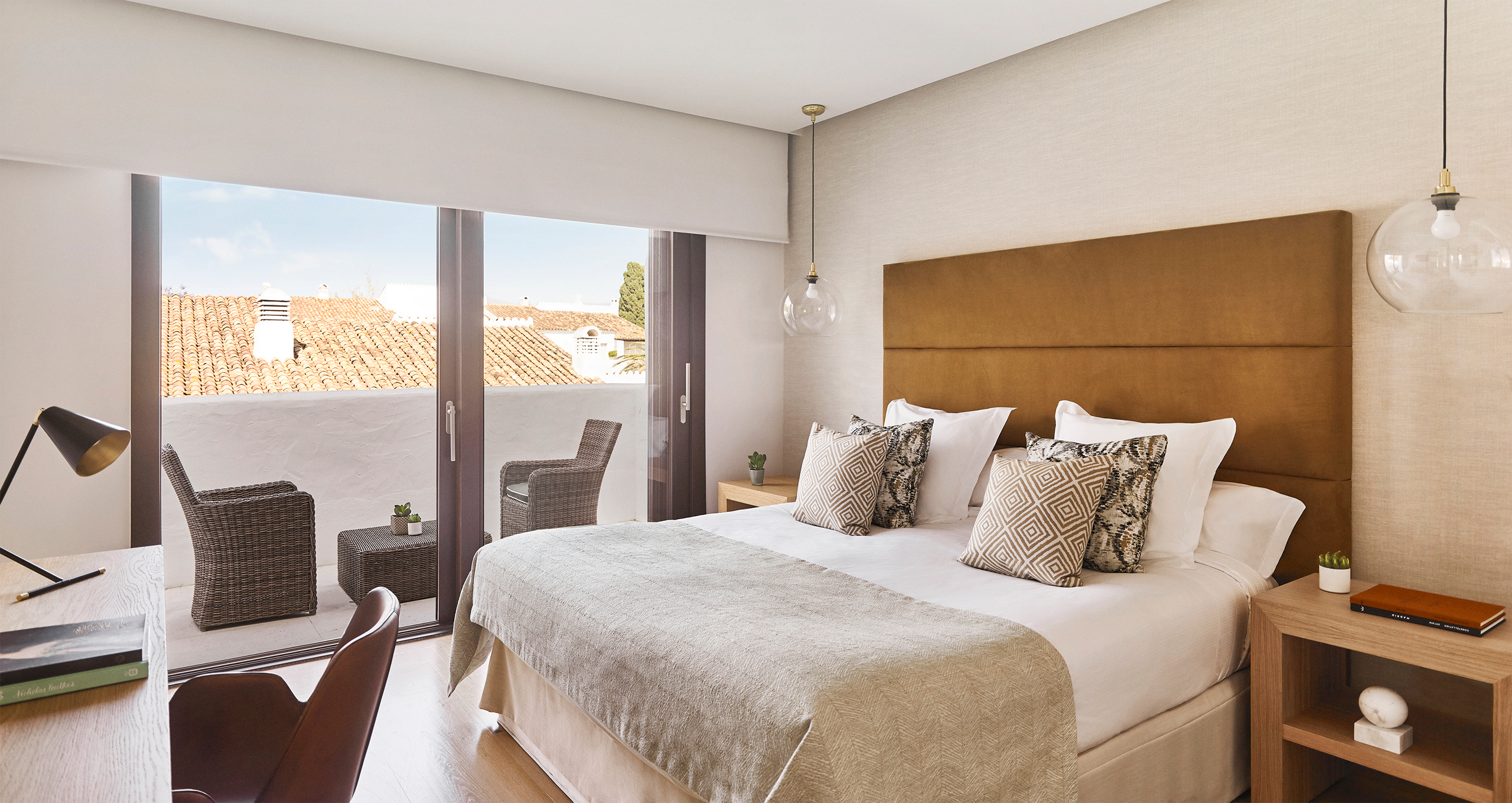 Cozy bedroom featuring a bed, a chair, and a balcony with natural light streaming in