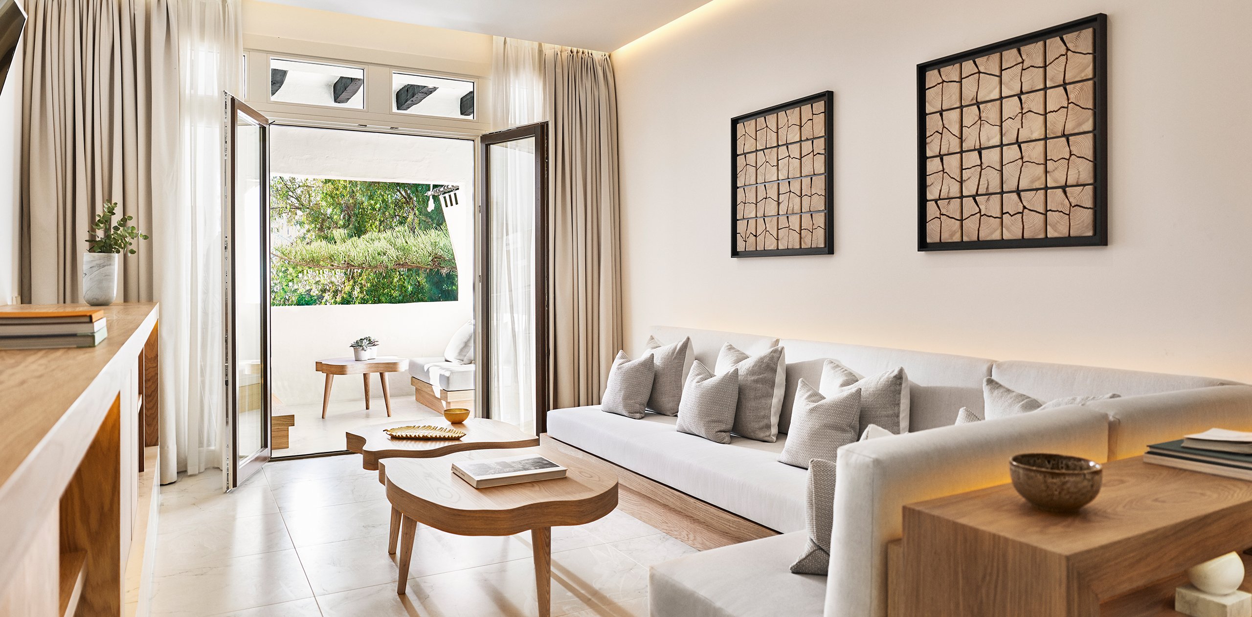 Cozy living room adorned with white furniture, showcasing a sliding door that leads to a beautiful patio