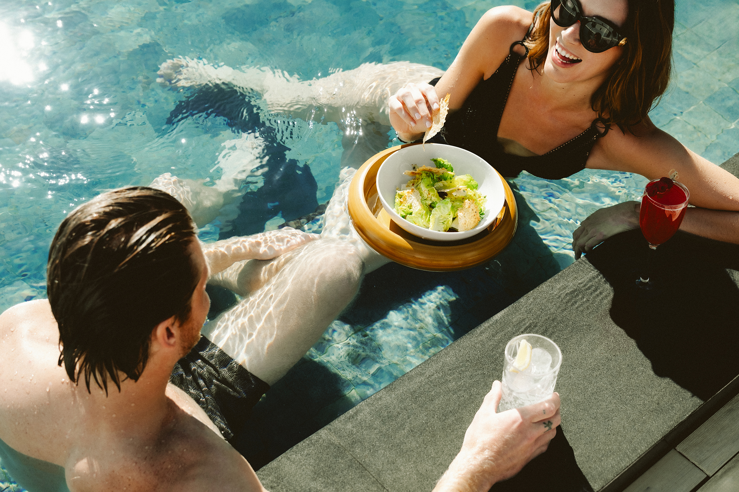 Couple enjoying the pool with food