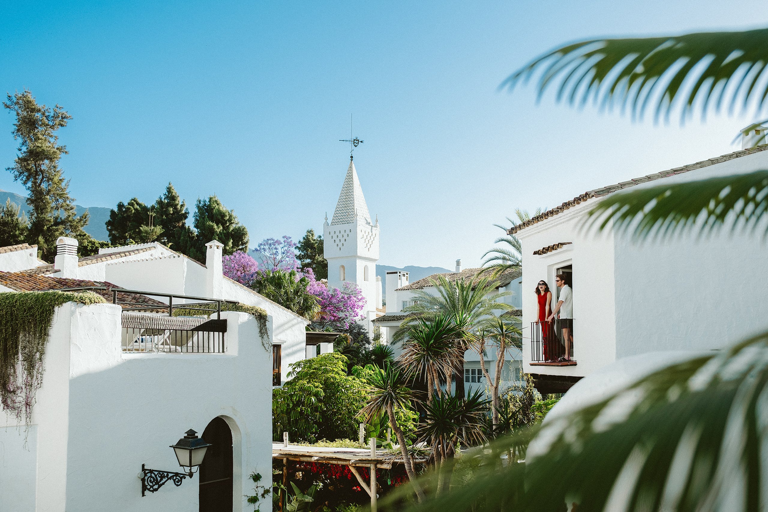 A picturesque small town featuring a white church and vibrant palm trees swaying gently in the breeze