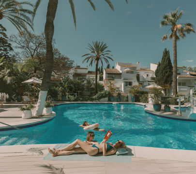 A relaxing scene of two individuals in a resort pool, soaking up the sun and enjoying their time togethe