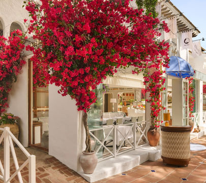 A lovely white structure featuring bright red flowers decorating its facade