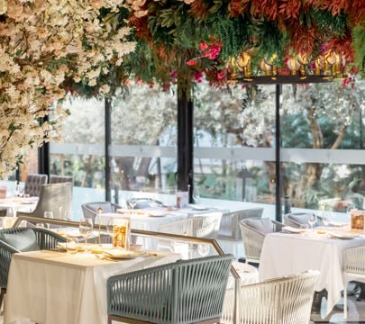 A delightful restaurant interior with flowers elegantly hanging from the ceiling, enhancing the inviting and cheerful vibe