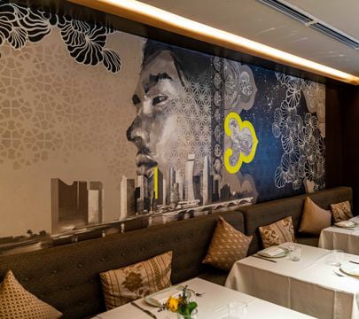 A lively restaurant scene showcasing a beautiful mural and well-set tables for guests to enjoy their meals