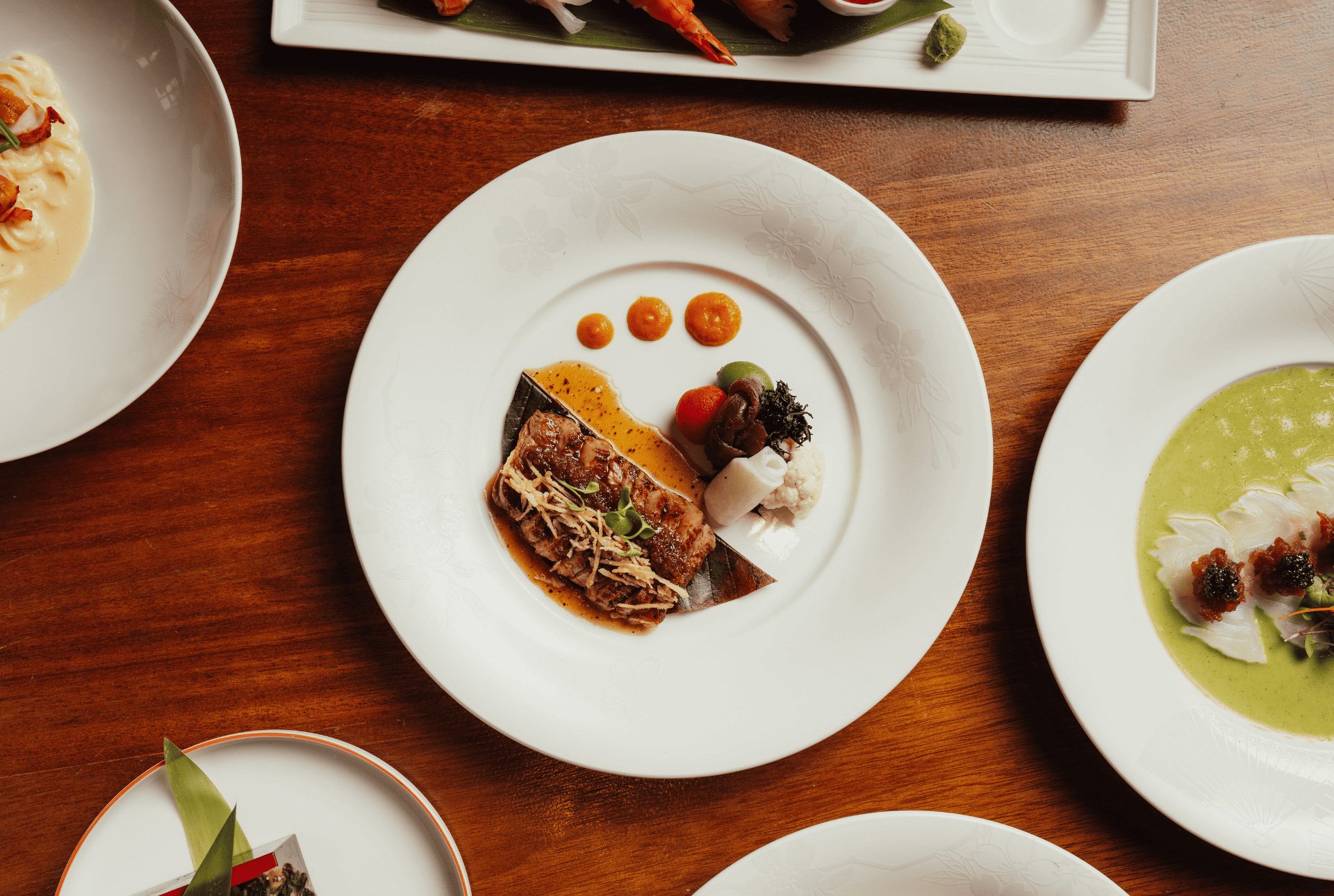 A table filled with an array of colorful plates and bowls brimming with delicious food.