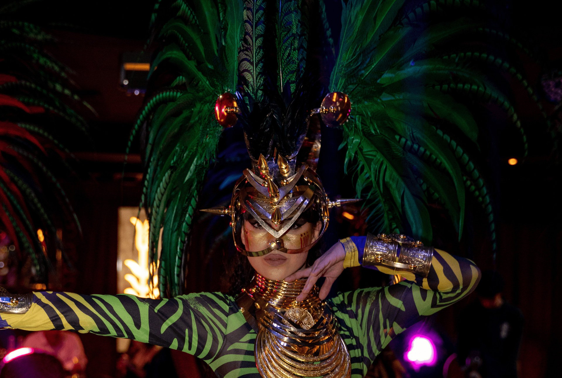 A masked woman in a vibrant costume, featuring feathers, showcasing a blend of beauty and intrigue.