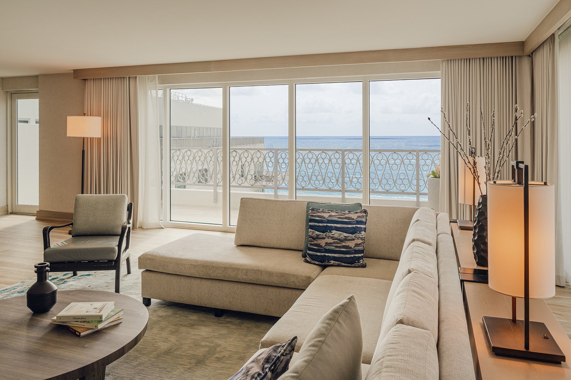 Large Sand Coloured couch and armchair with beach view through balcony window