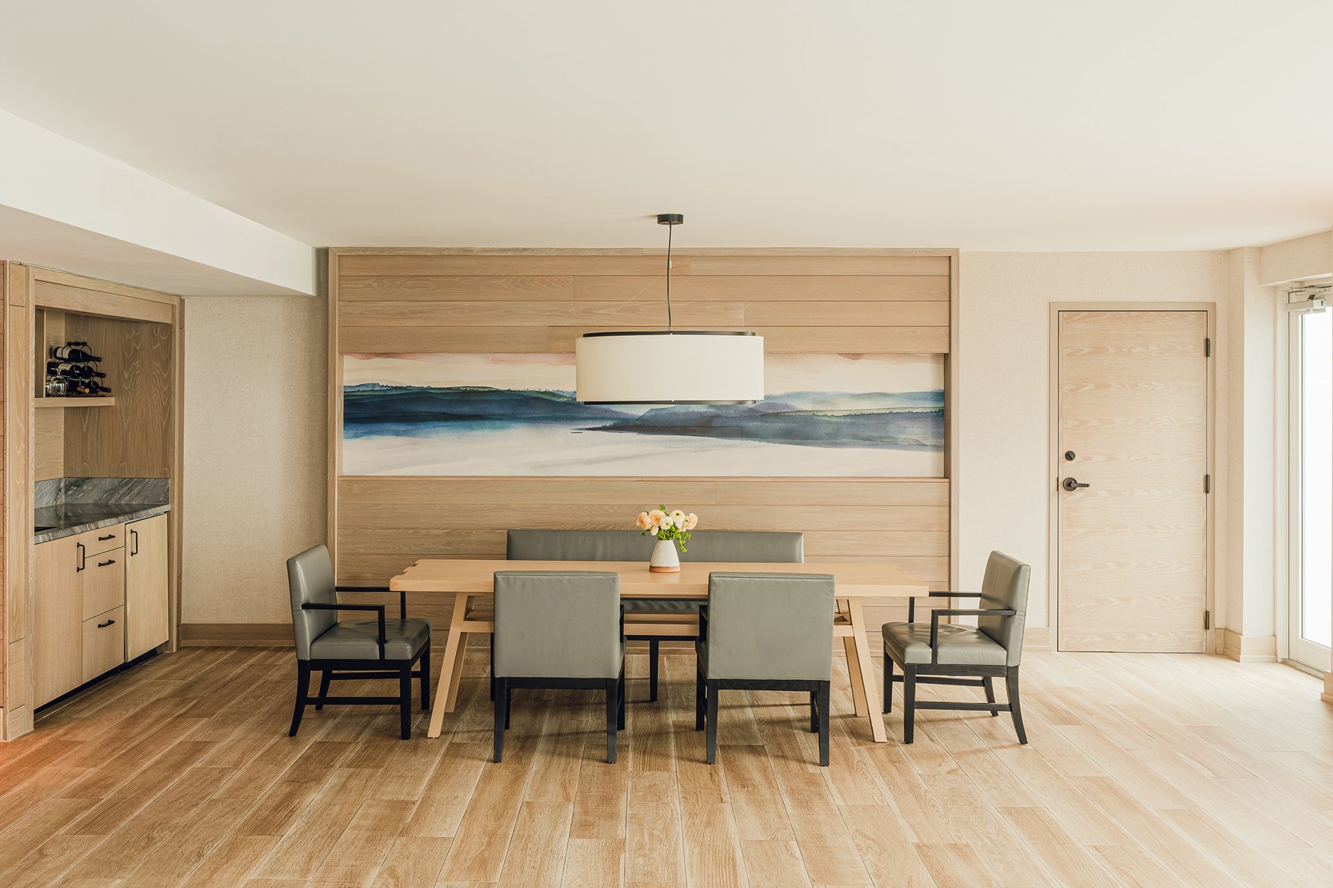 large dining table and khaki coloured armchairs in modern kitchen area