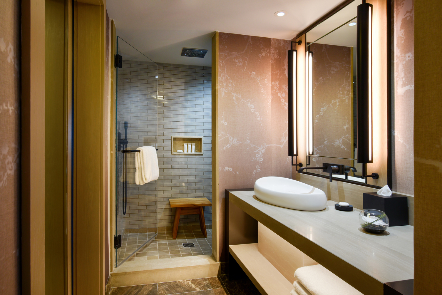 Sink, big mirror with the toned down pink wall and bathtub with grey wall in bathroom