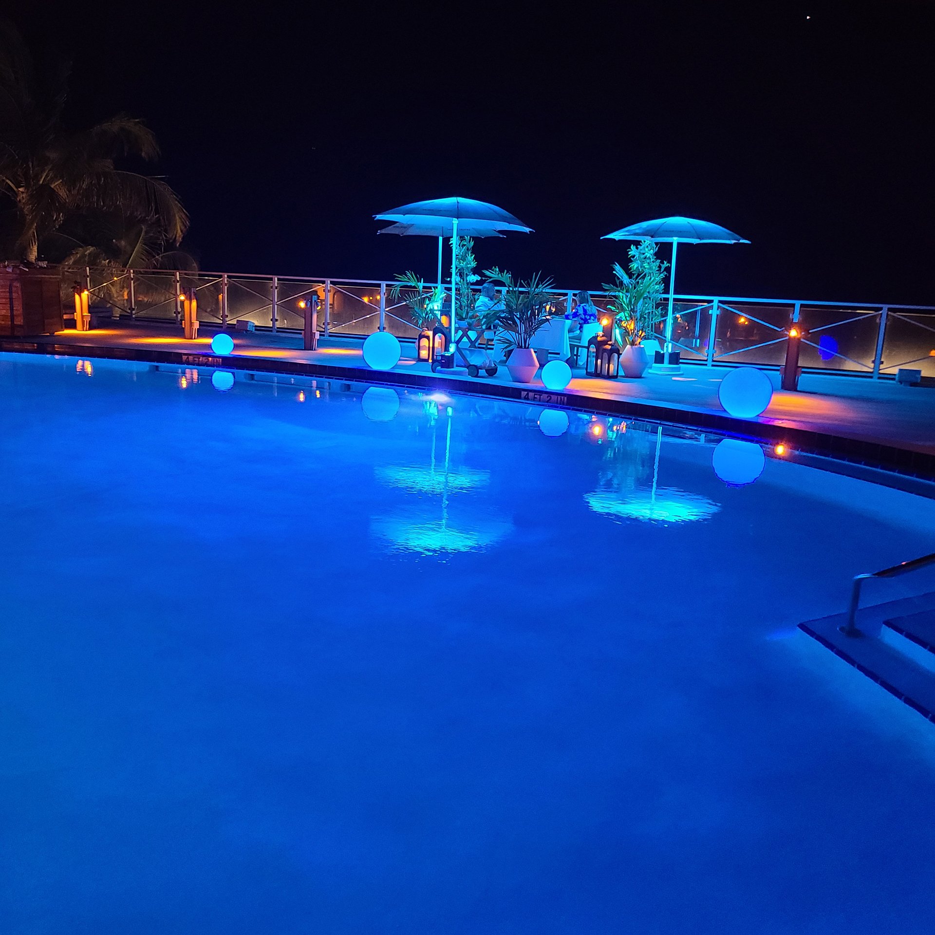 Romantic couple for private dining from the pool at night