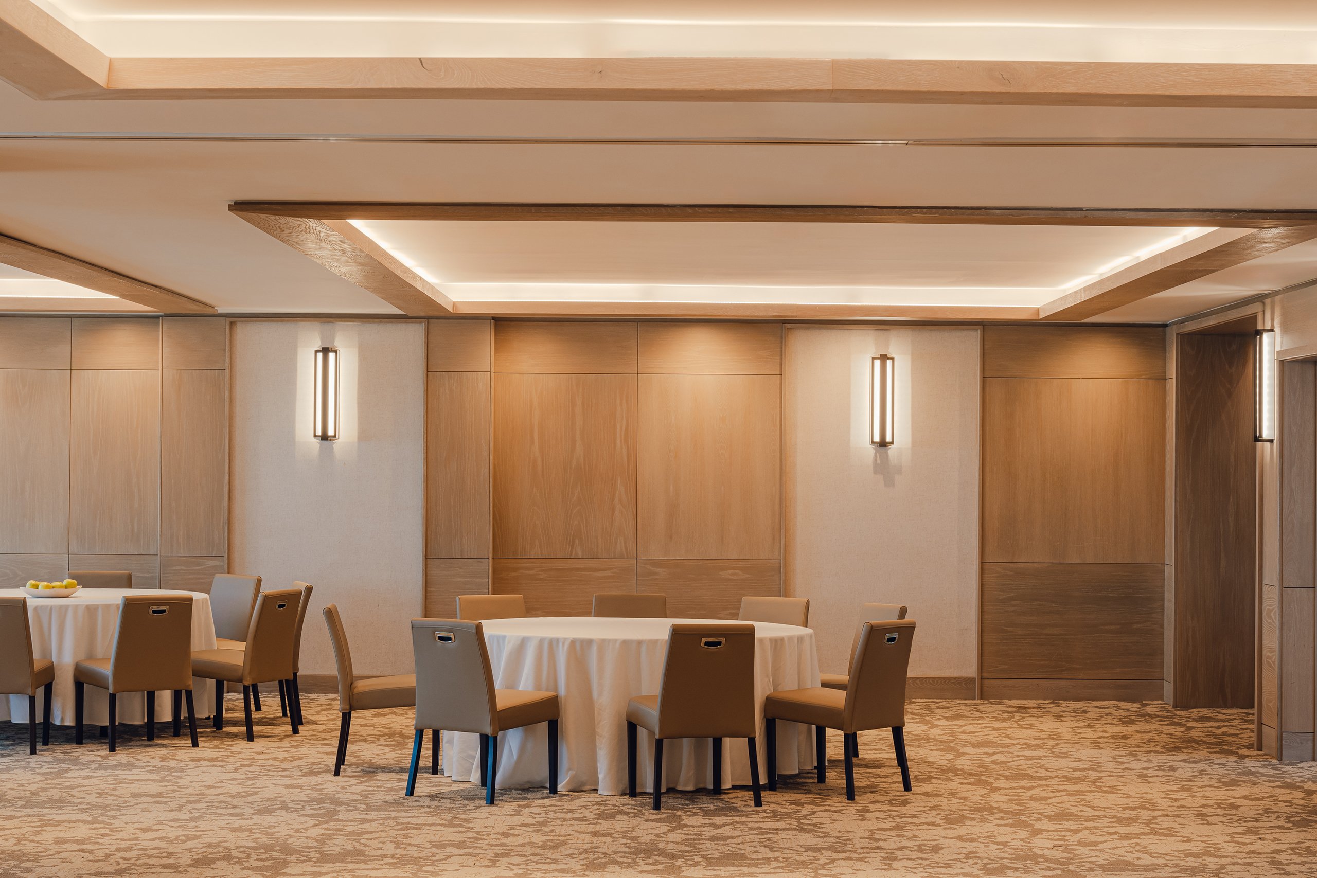 Round tables and comfortable chairs in the wooden color wall