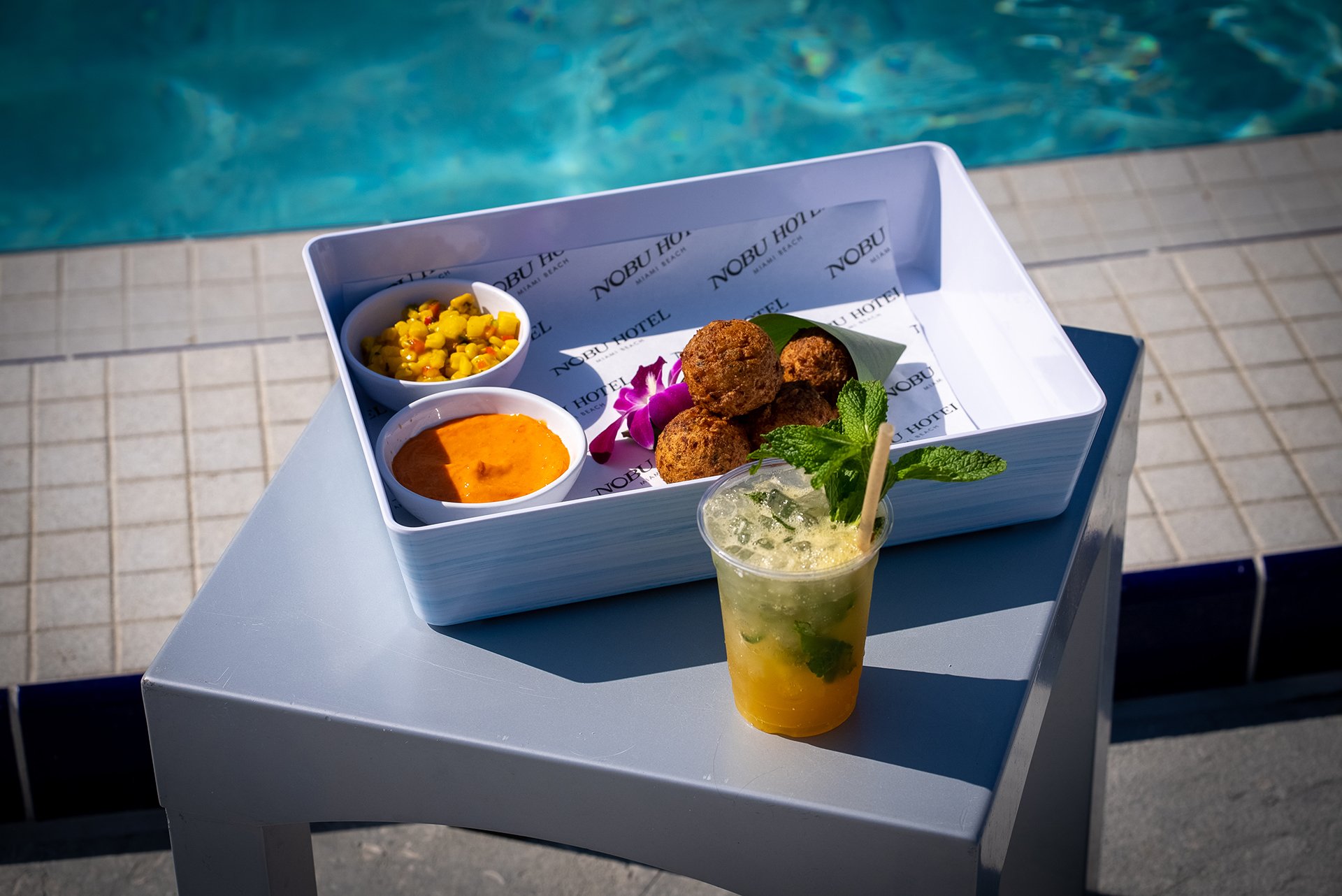 Some snack food and cocktails near the pool