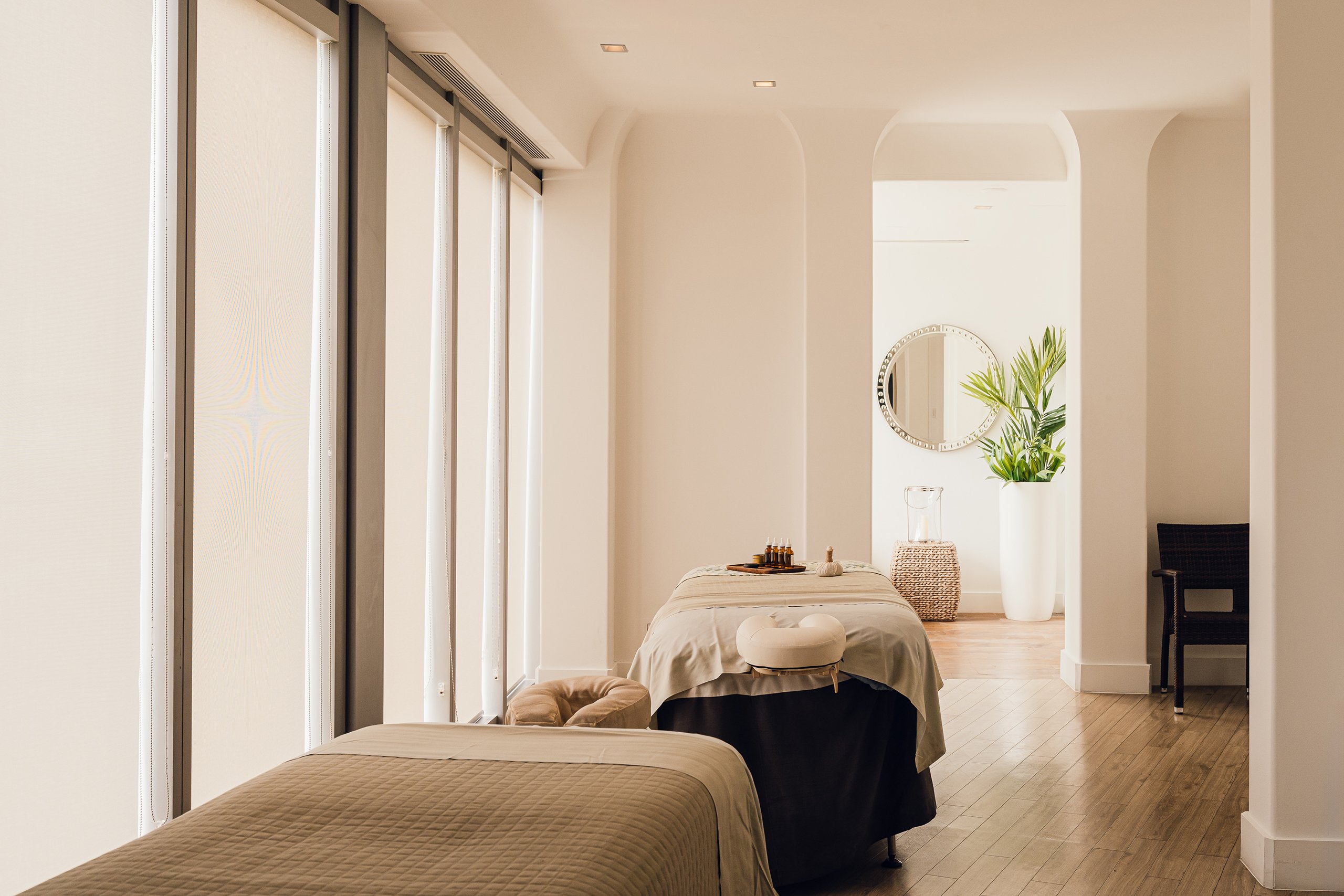 Spa beds, round mirror, and plant