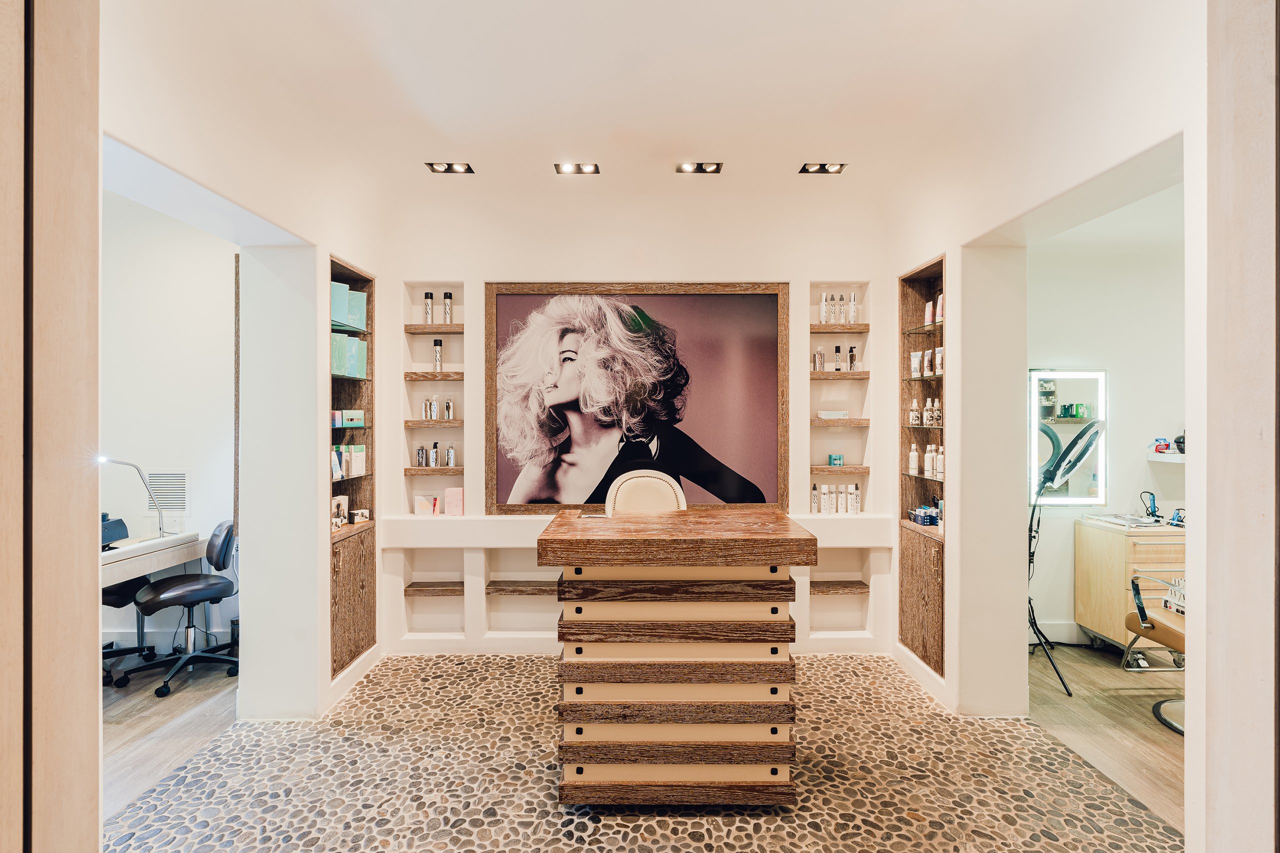 Curly hair woman in the picture frame and some cosmetics on the wall with the wooden table