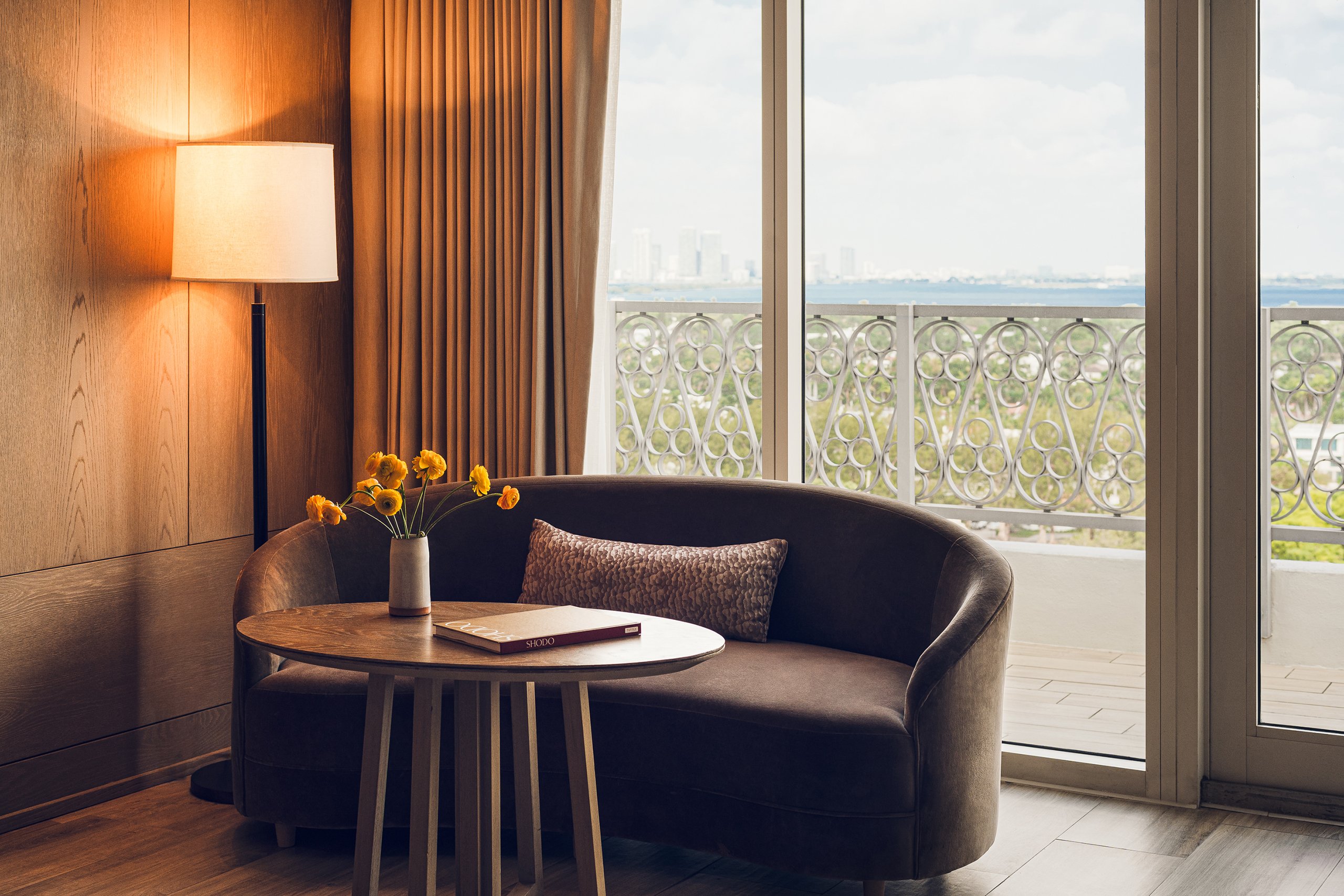 brown coloured couch and tea table with window from the balcony