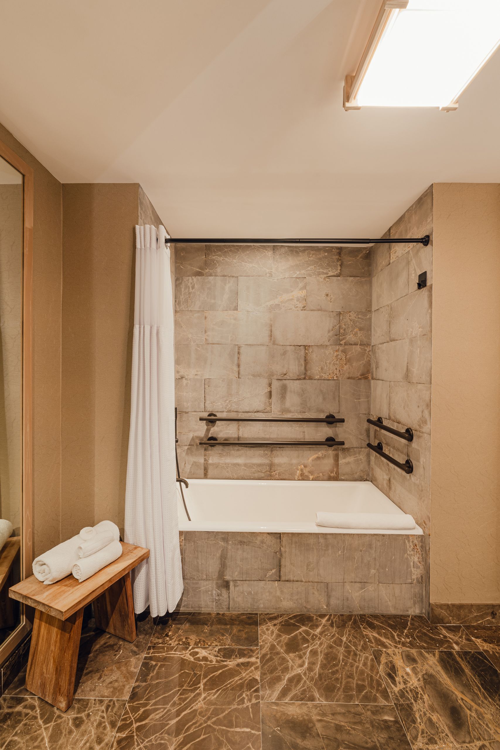 bathtub in stone coloured bathroom