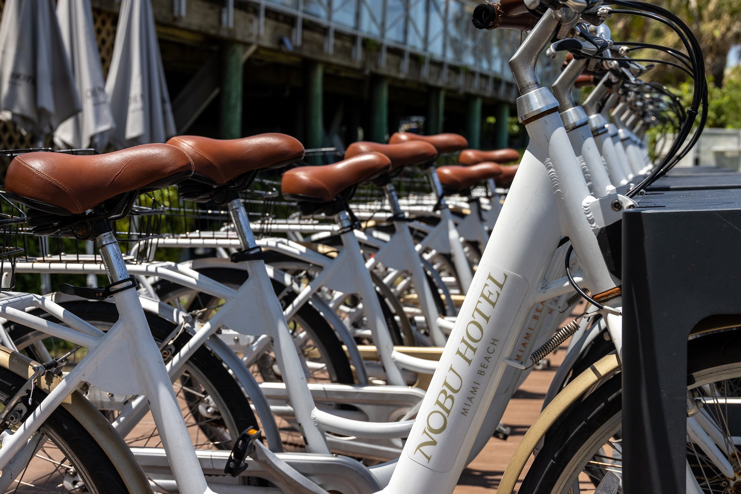 A series of bicycles arranged in a row, highlighting their different colors and styles against a bright backdrop