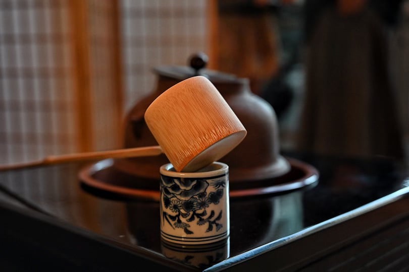 A wooden spoon resting on a sleek black table, showcasing its natural texture against the dark surface