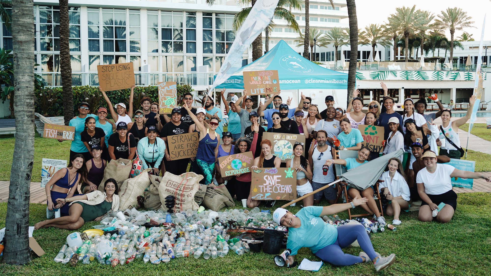 A group of people happily cleaning up trash on a sunny beach, working together to keep the shoreline beautiful.