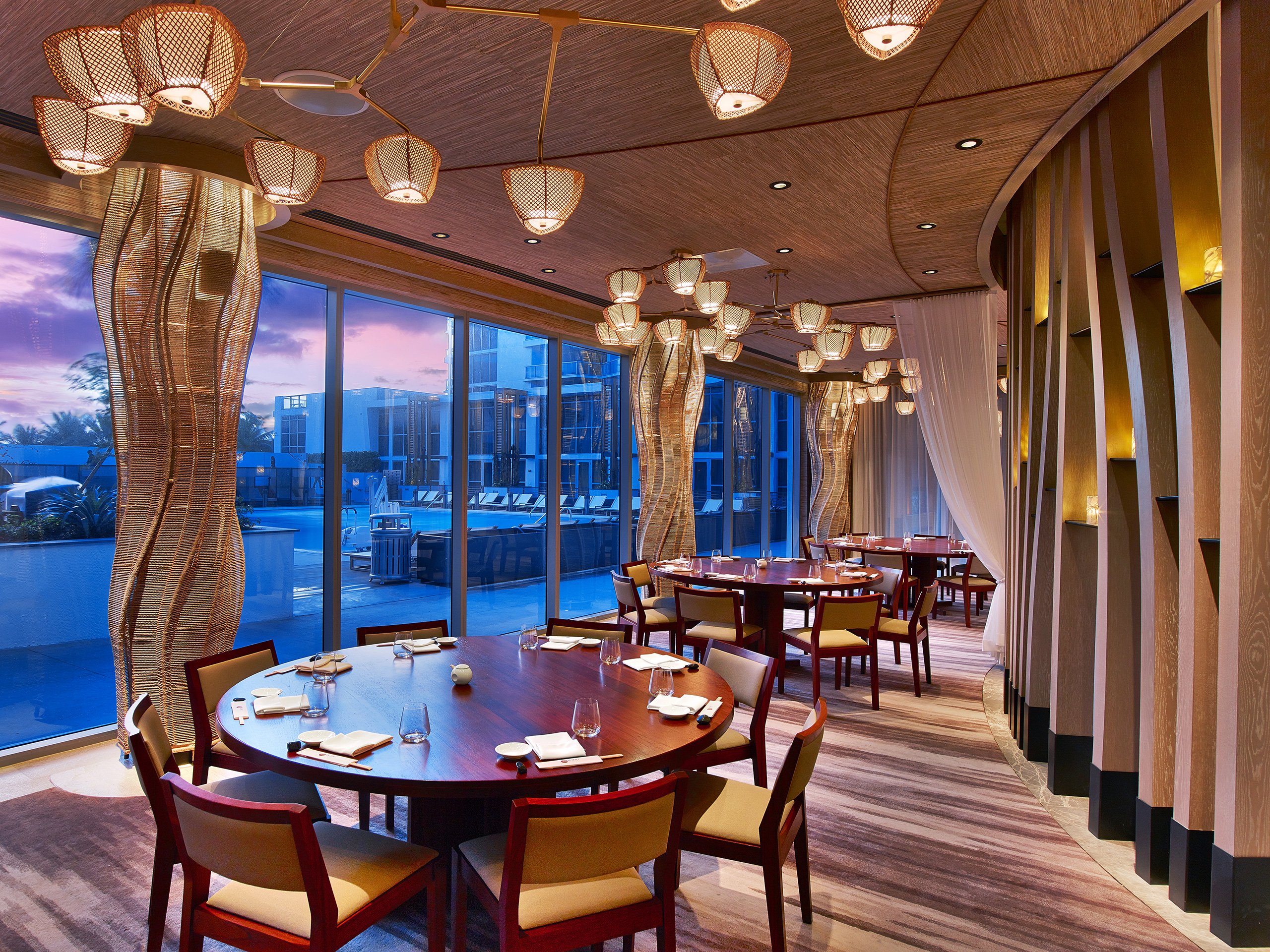 A large dining room in a restaurant, illuminated by sunlight streaming through its generous windows