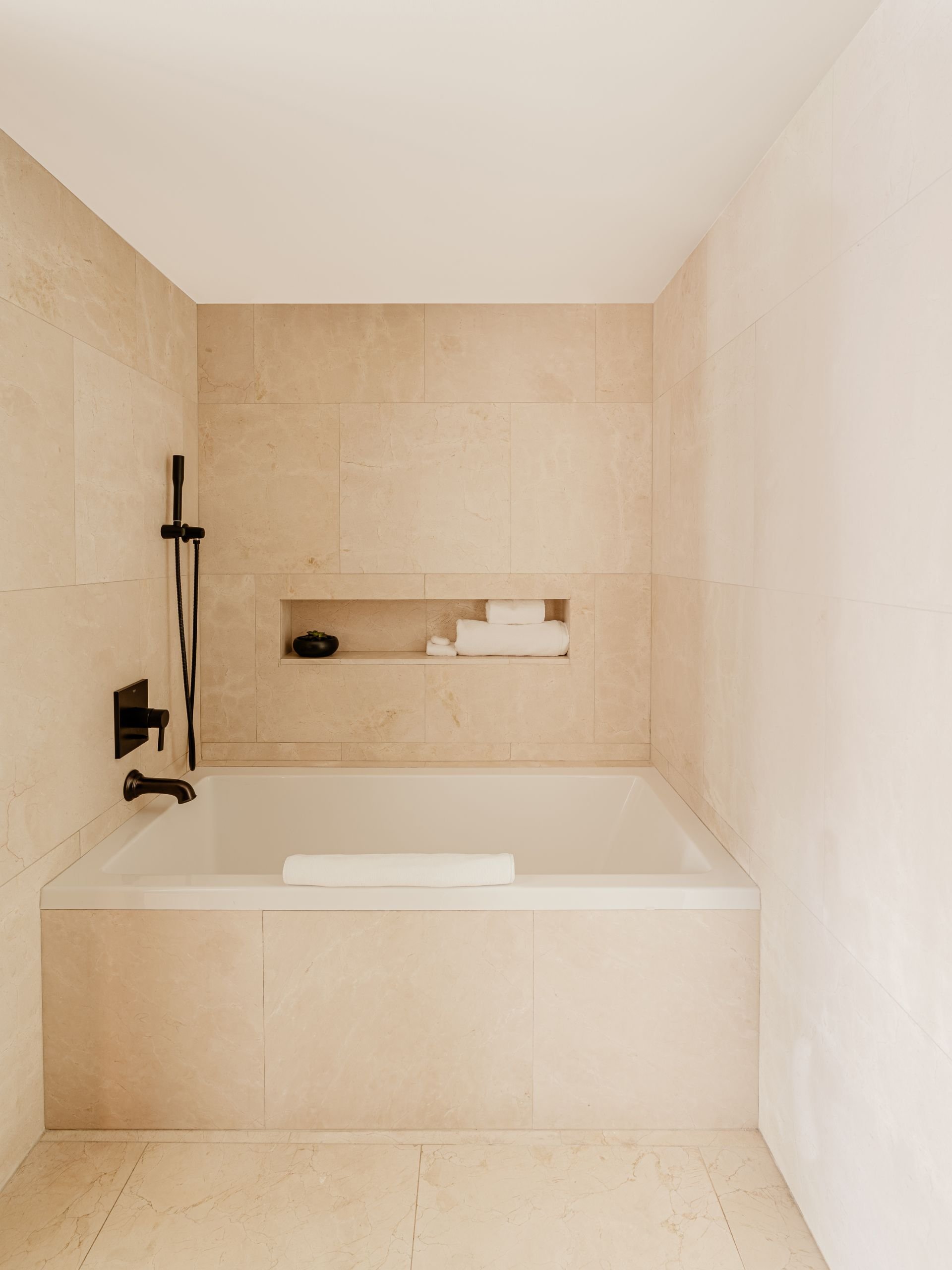 Square shaped white bathtub with ivory wall