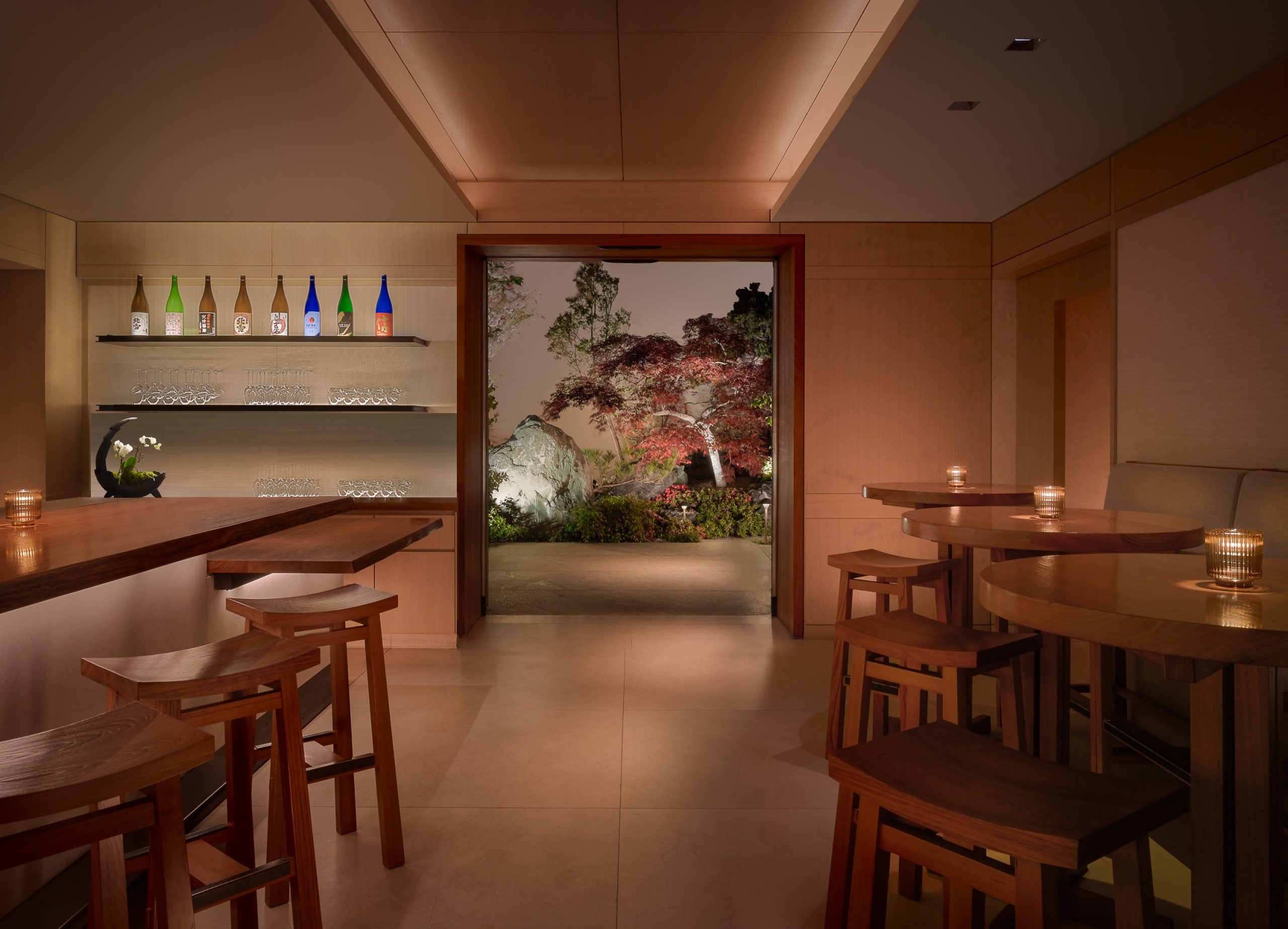 A stylish bar scene with stools lined up and a door on the wall, inviting for a relaxed evening out