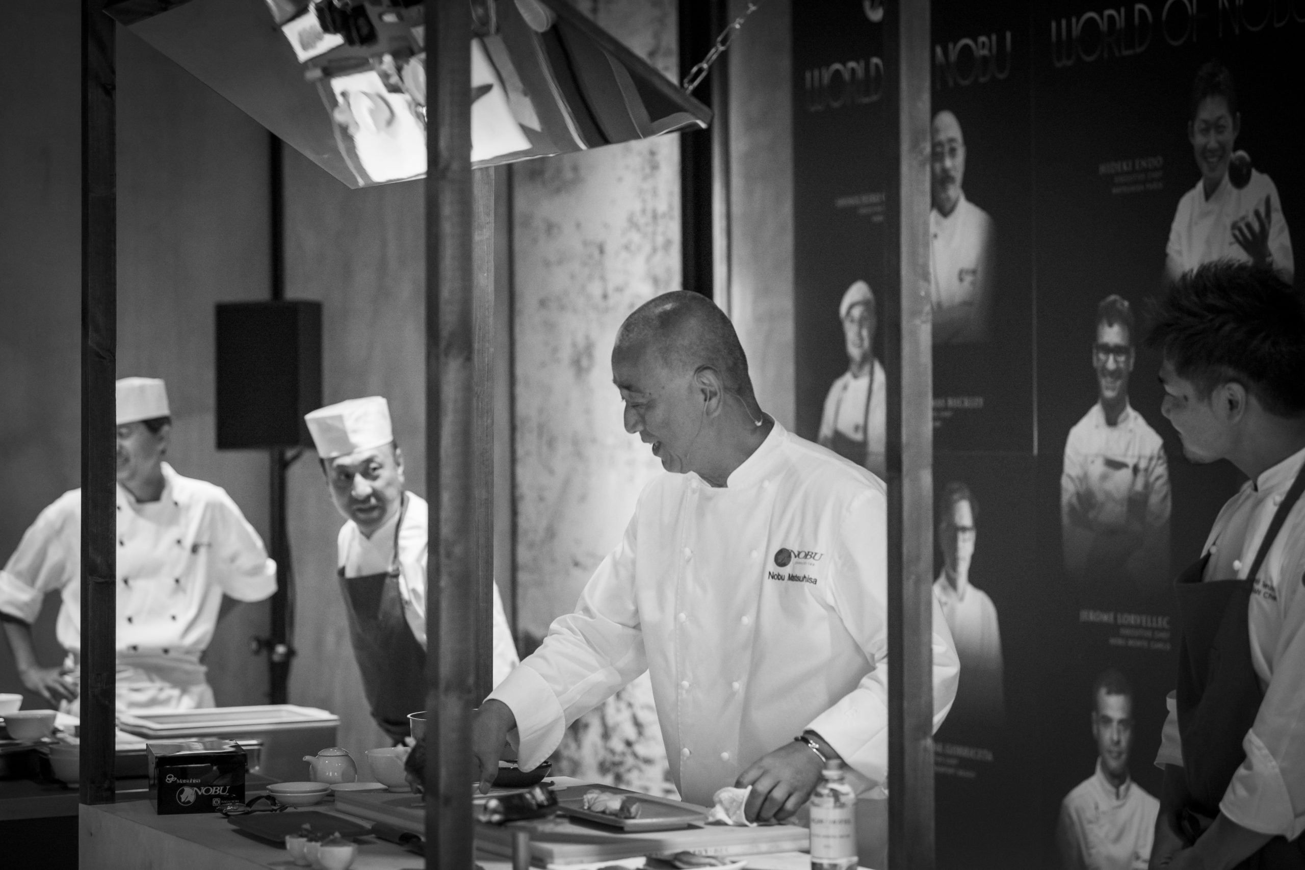 Chefs and Nobu preparing delicious dishes at a lively restaurant