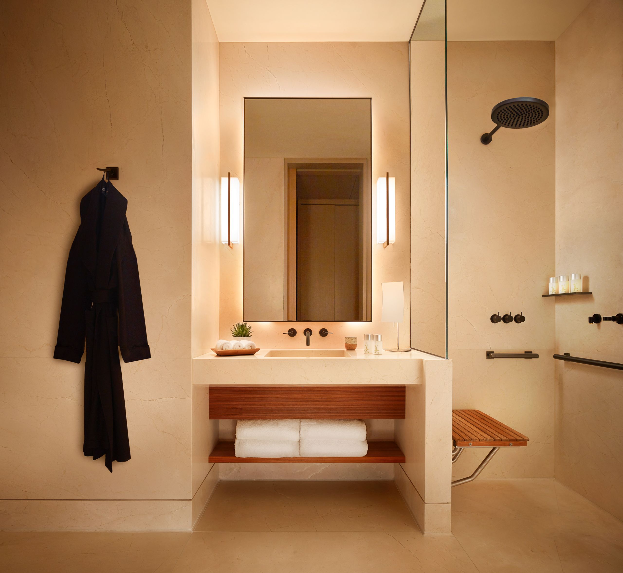 Nobu bathroom vanity with walk in shower and black robe on the wall.