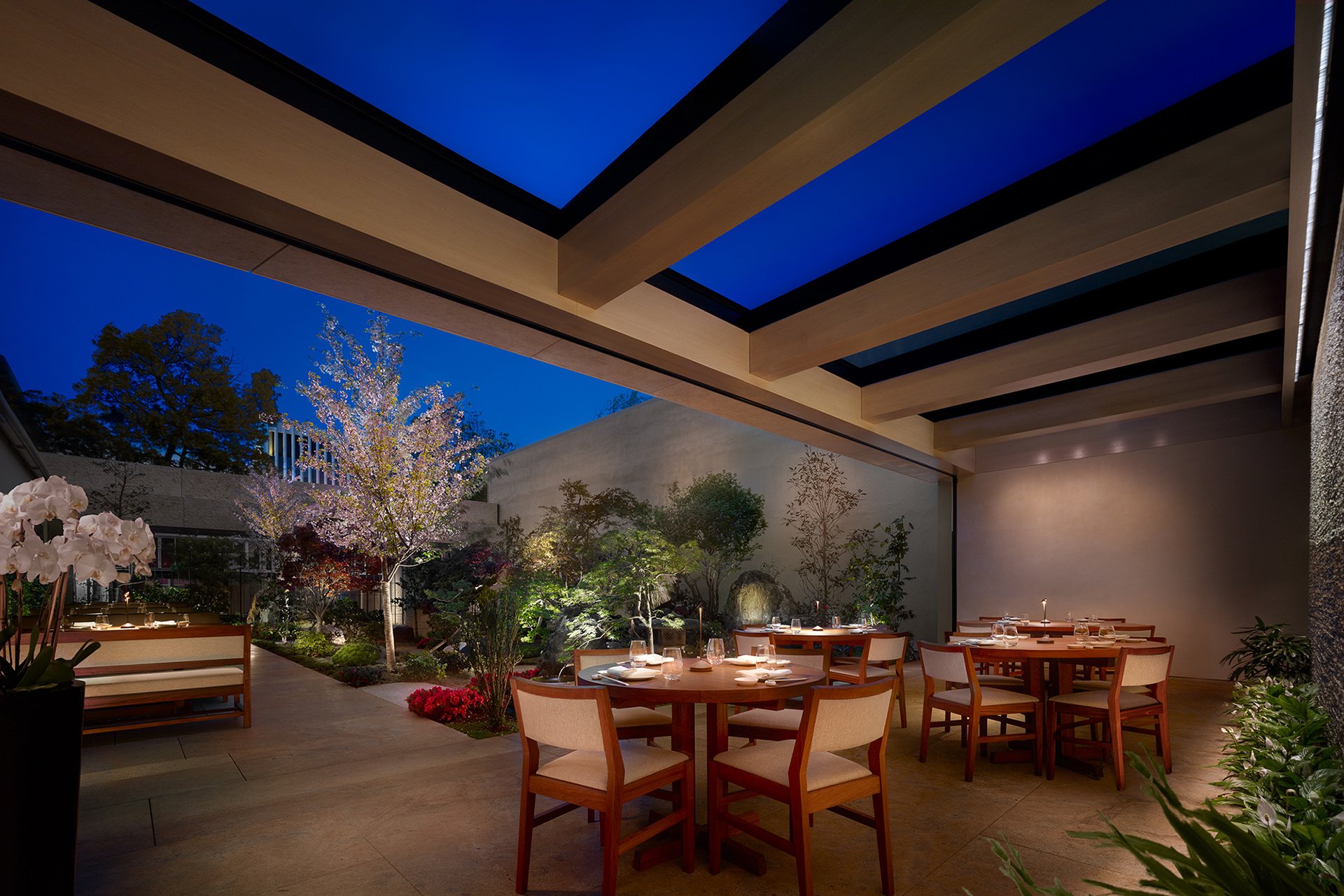 A spacious restaurant featuring a large dining area illuminated by a beautiful skylight overhead