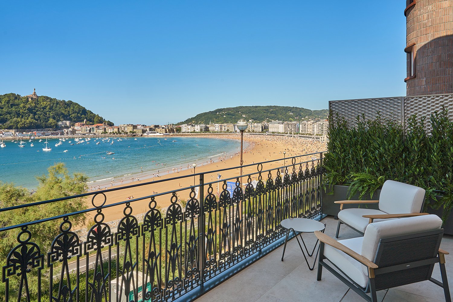 white comfortable chairs armchairs and tea table at premium terrace with the beach view