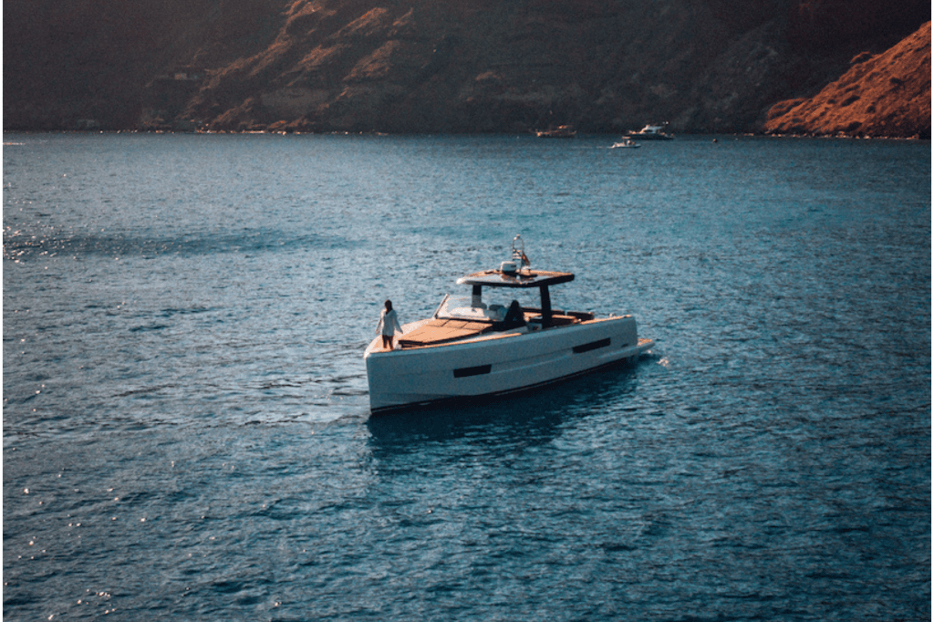 A peaceful scene of a boat gliding on water, framed by a stunning mountain landscape