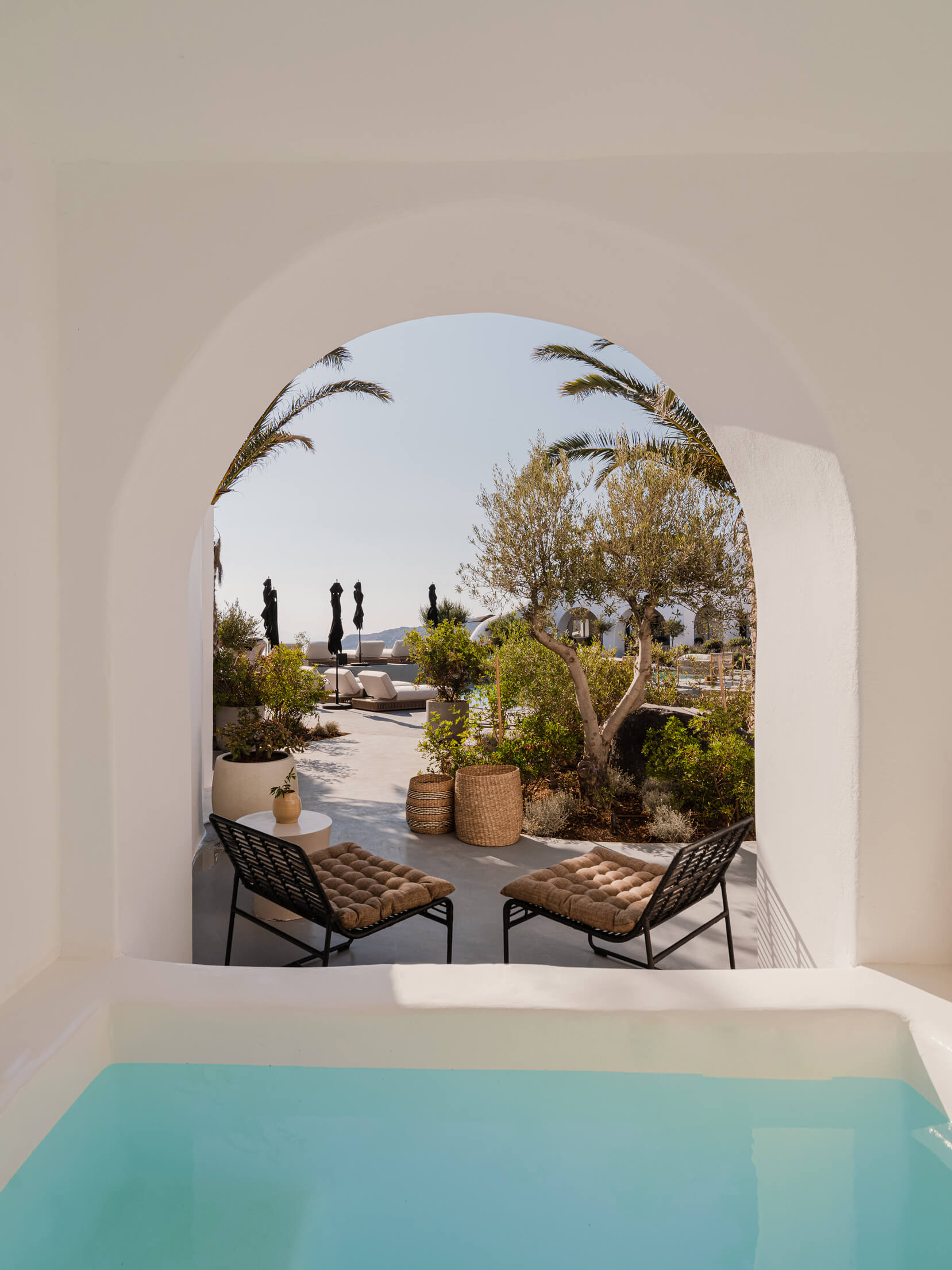 A picturesque pool scene seen through an elegant archway, creating a perfect blend of architecture and nature