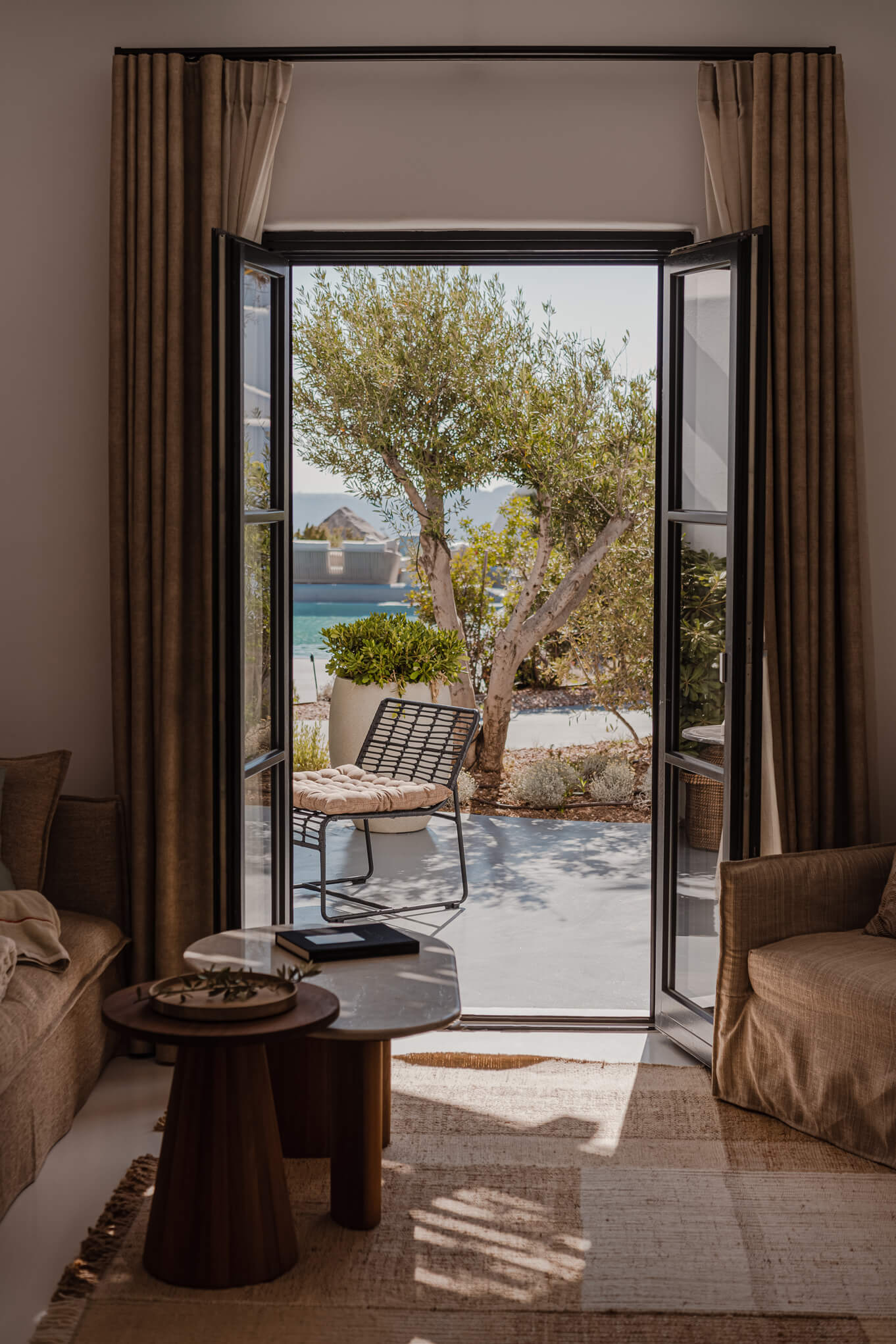 Bright living room with comfortable seating and expansive windows offering a breathtaking ocean view