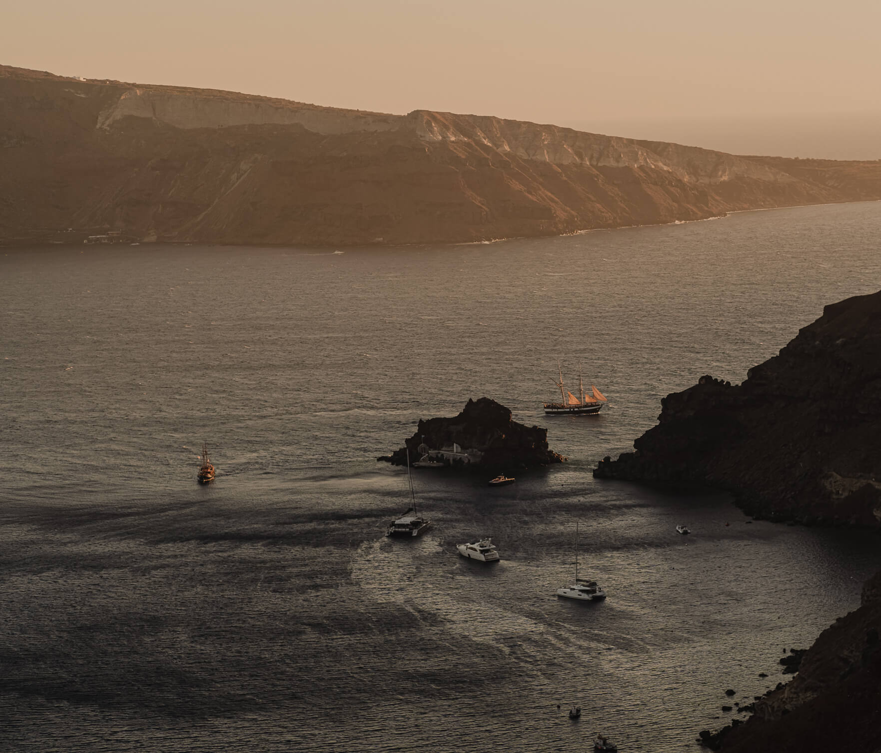 Scenic view of boats floating near a cliff in Santorini, capturing the essence of the island's coastal charm