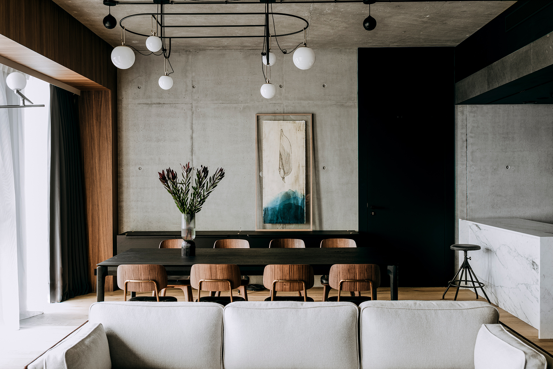 A chic modern living room with a comfortable white couch and a warm wooden table, ideal for a welcoming space.