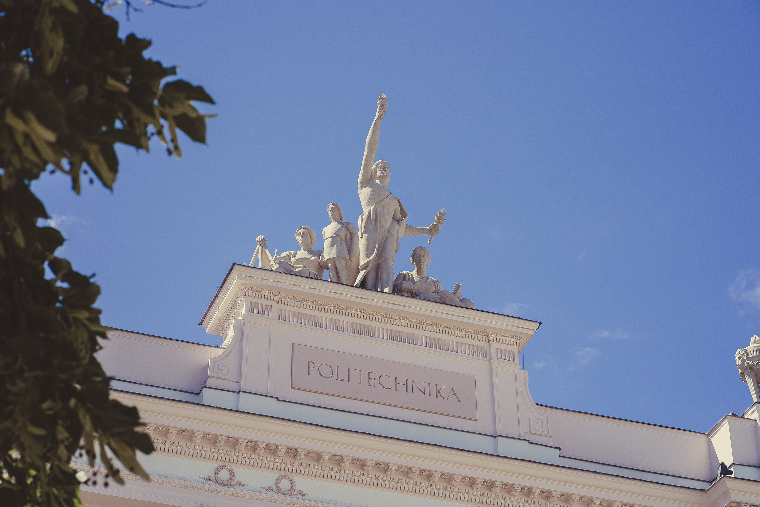 A statue of a man stands proudly atop a building